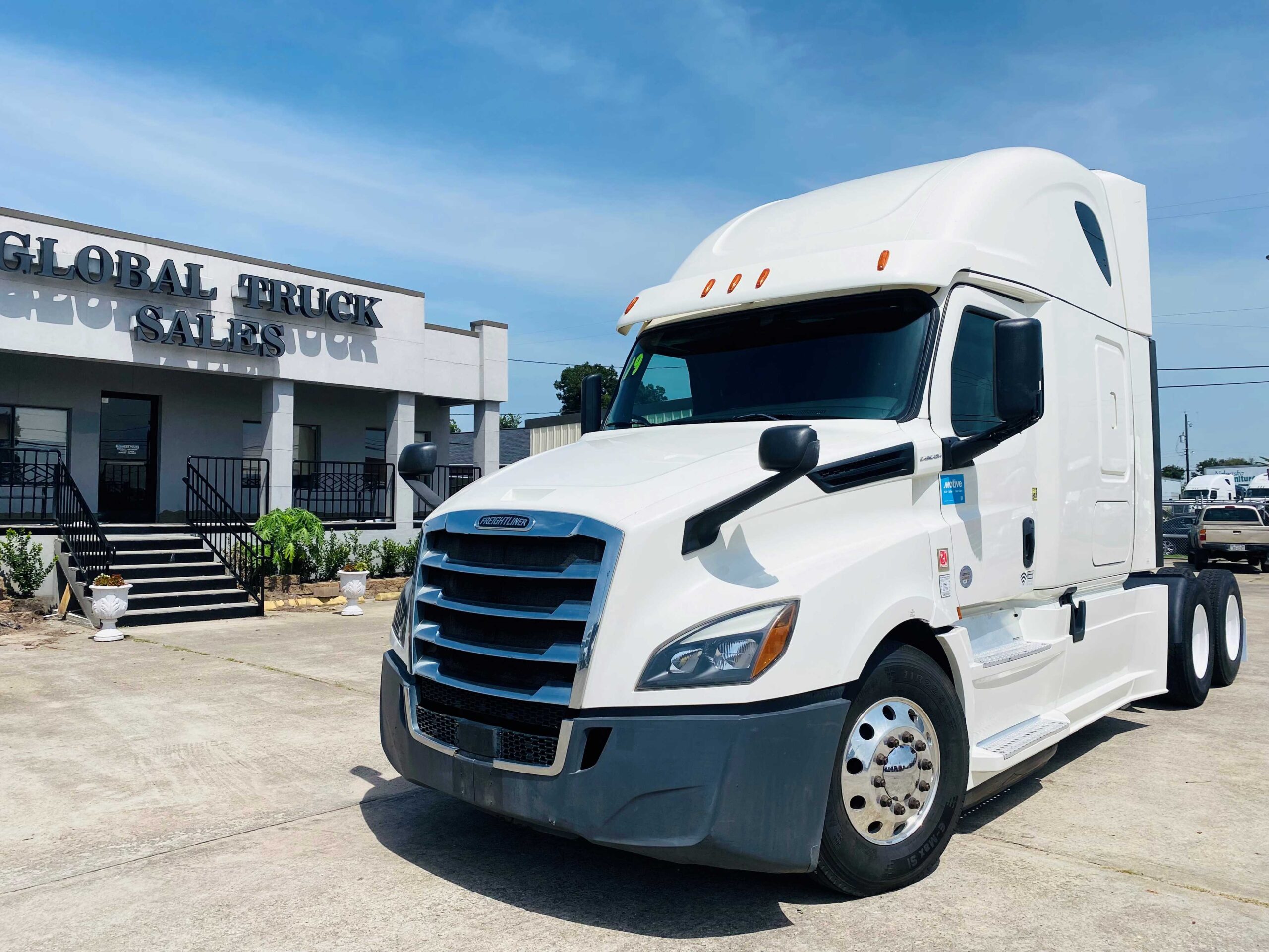 White semi-truck parked near dealership