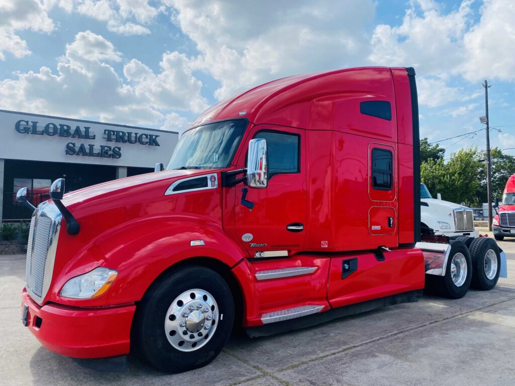 Red semi-truck parked outside dealership