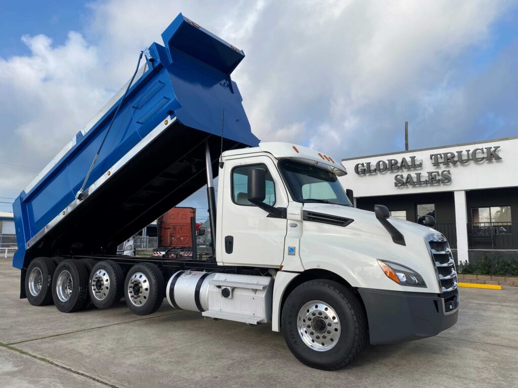 White dump truck with blue trailer raised.