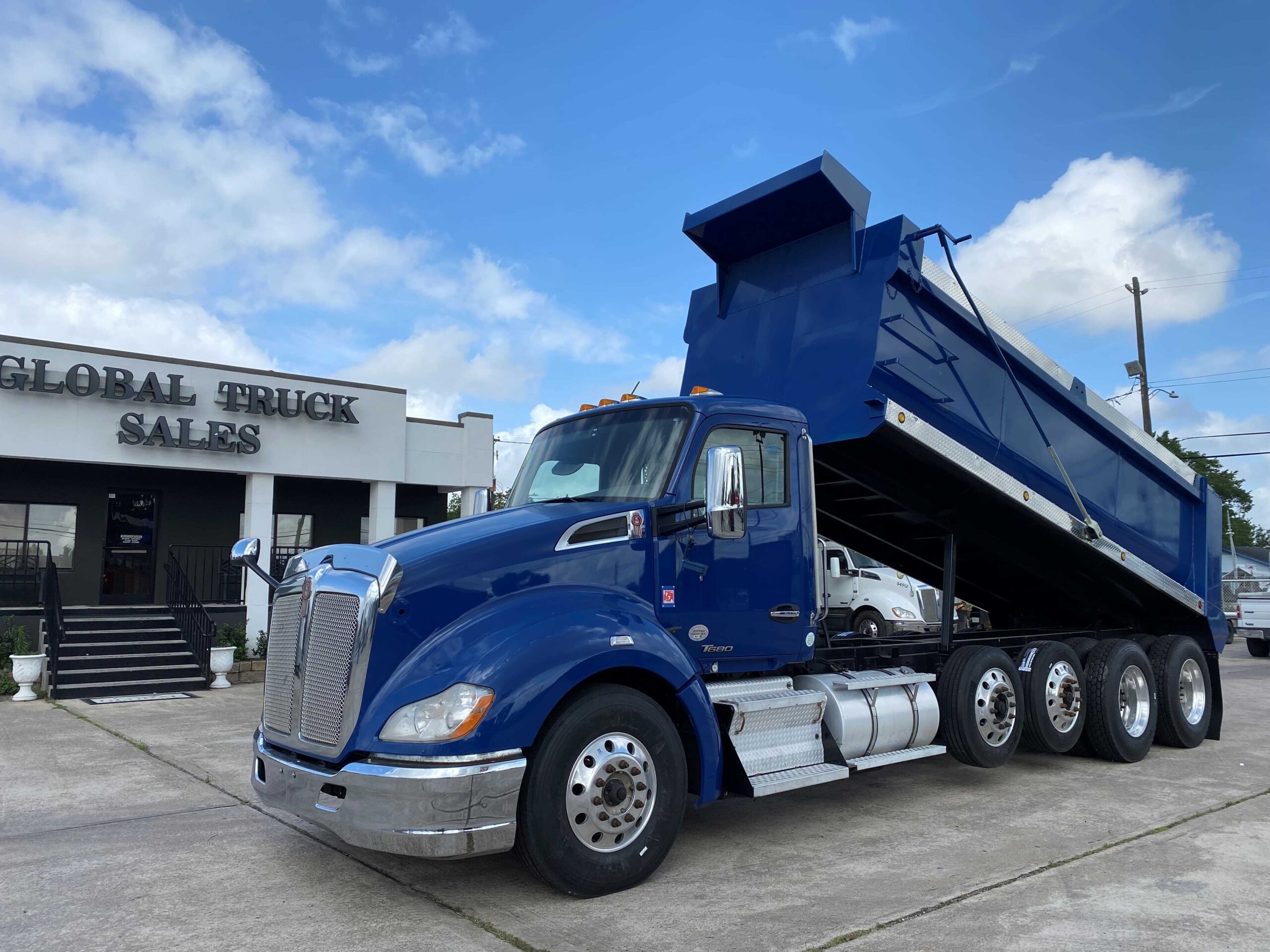 Large blue truck near dealership