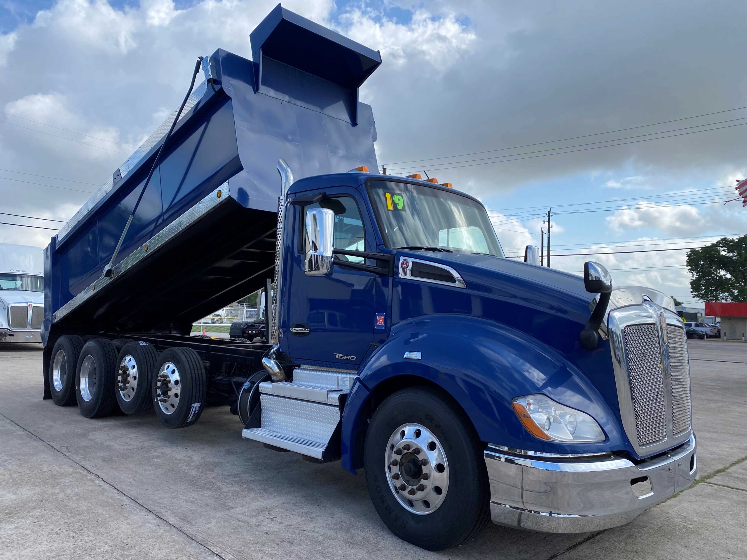Large blue truck under cloudy sky