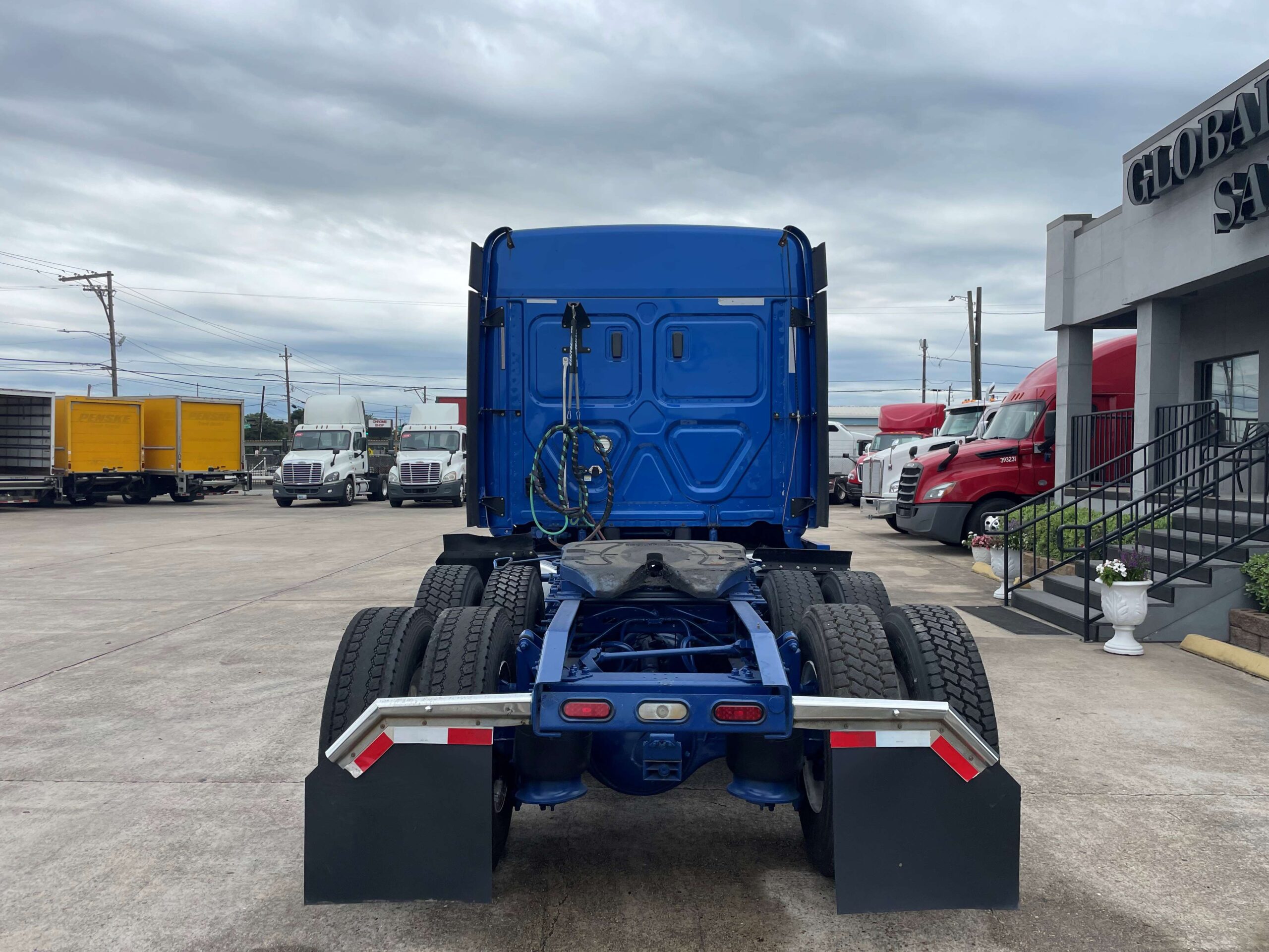 Blue truck parked in dealership lot.